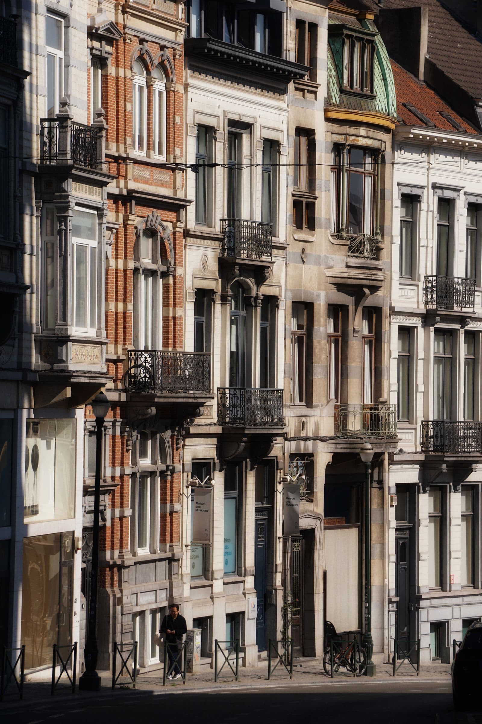 Façades de maisons bruxelloises typiques, briques et balcons en fer forgé