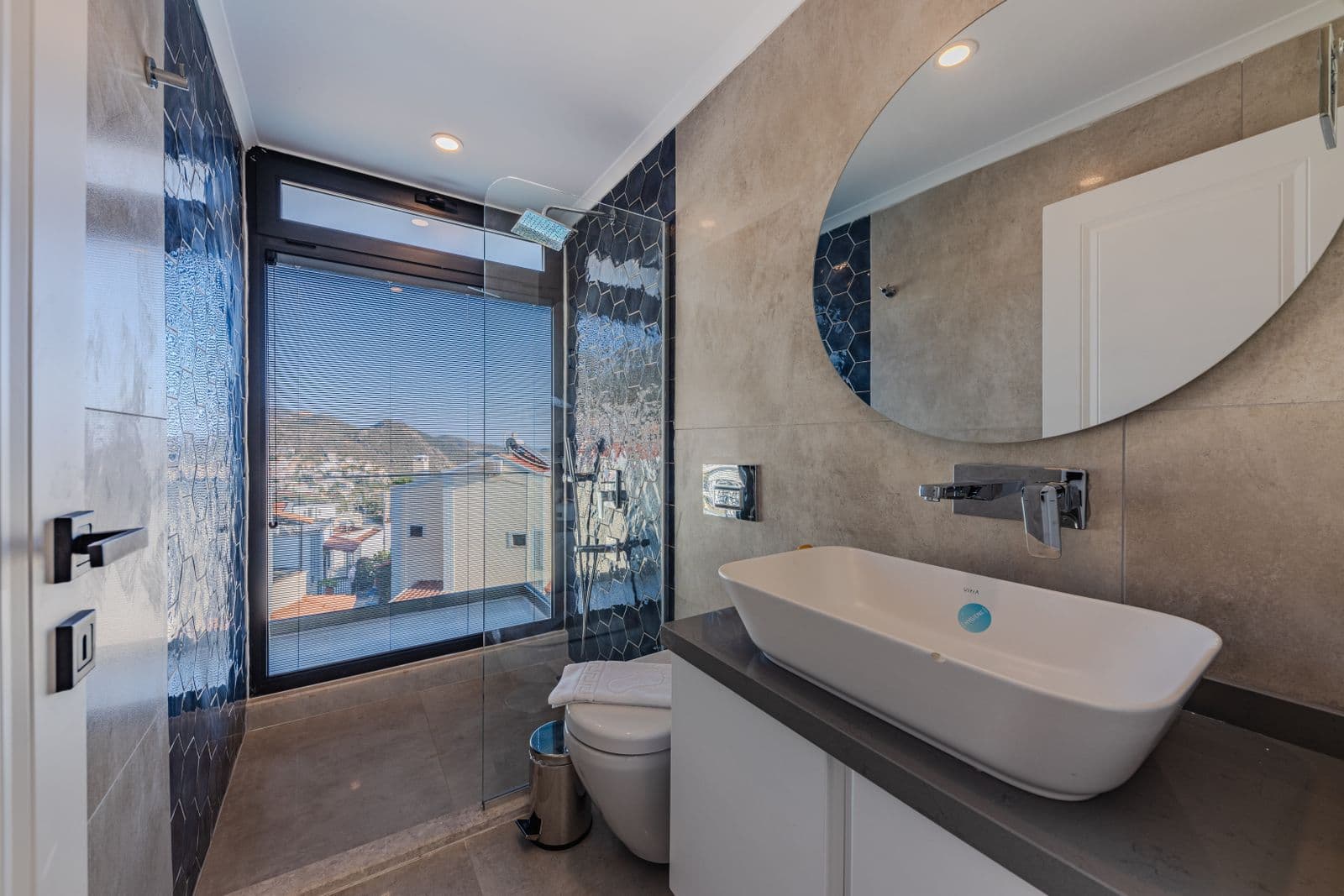 Salle de bain moderne et lumineuse : vasque design, douche vitrée, robinetterie murale