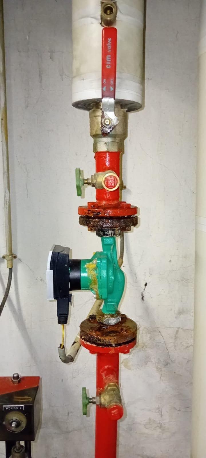 Ancien circulateur de chauffage grippé avant remplacement, brides oxydées