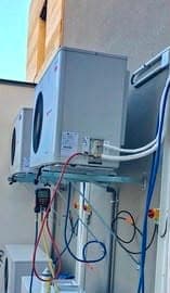 Groupes extérieurs de climatisation posés sur consoles en façade à Uccle